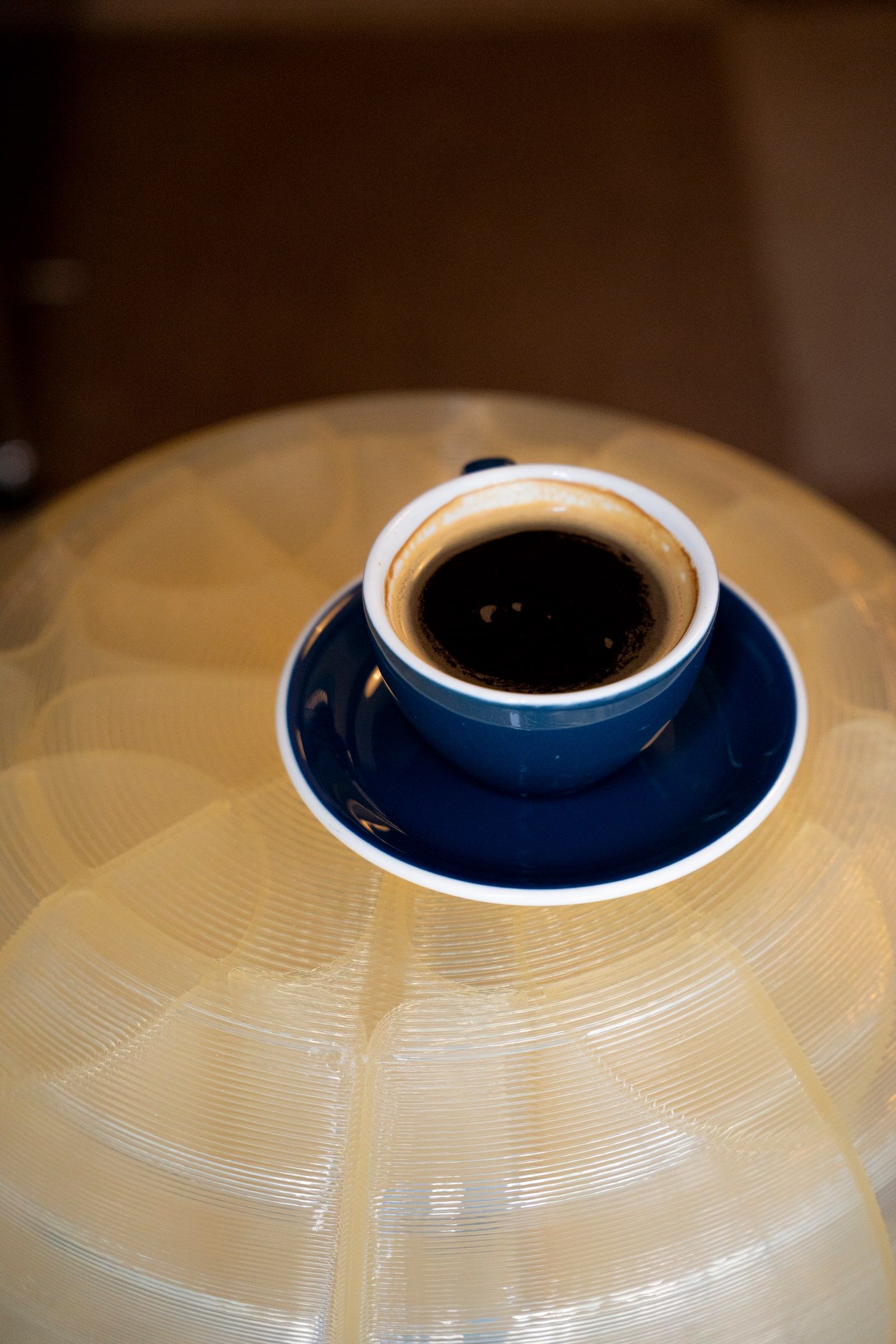 A black coffee in a blue cup and saucer